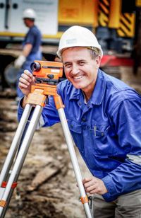 Bauarbeiter mit Vermessungsgerät auf einer Baustelle in Hamburg